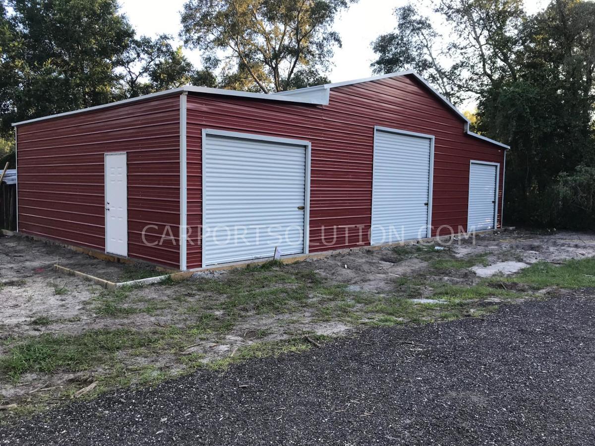 Red metal barn with roll-up doors built in Florida by Carport Solution